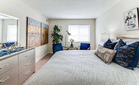 a bedroom with a bed and a dresser and a window