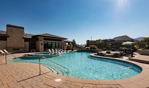 A sunny day at a pool with a mountain in the background.