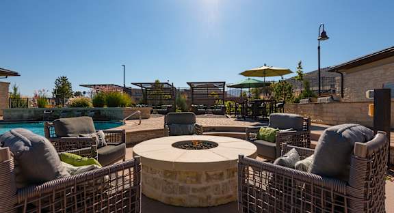 A sunny day at the outdoor seating area with a fire pit in the center.