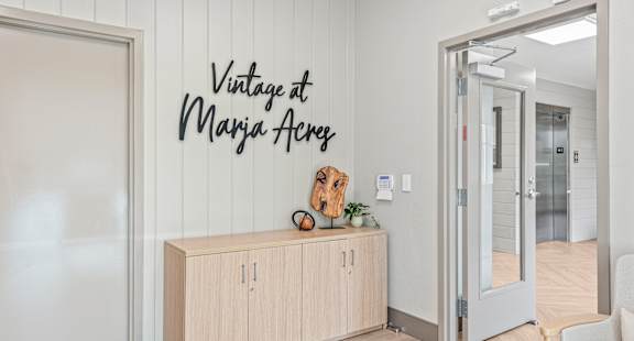 A room with a wooden cabinet and a sign that says "Vintage at Manja Acre".
