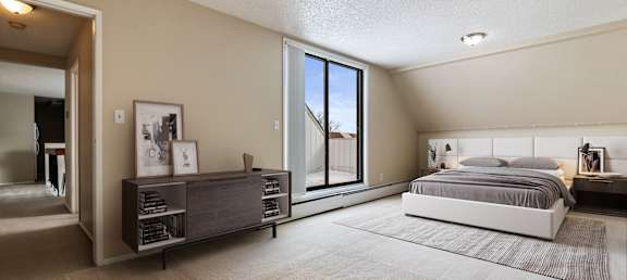 A bedroom with a large bed and a window overlooking a tree.