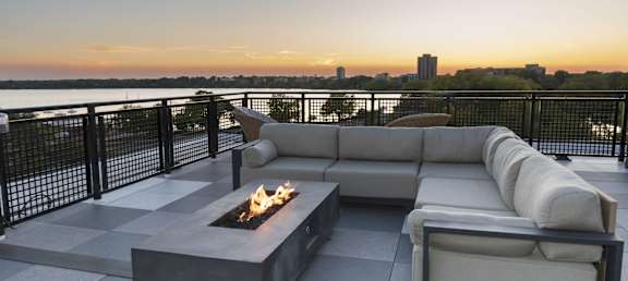 a living room with a couch and a fire pit on a rooftop