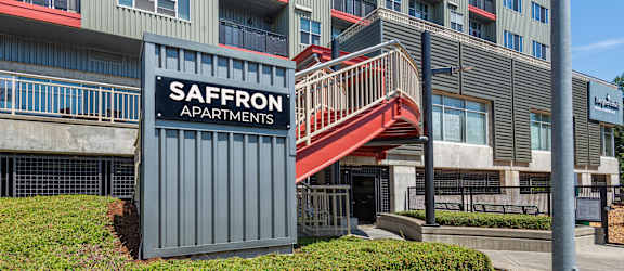 A multi-story building with a sign that says Saffron Apartments.