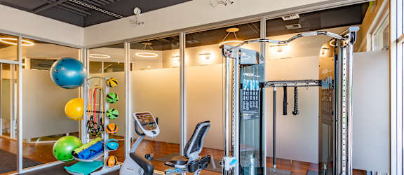 A gym with a treadmill, exercise balls and weights.