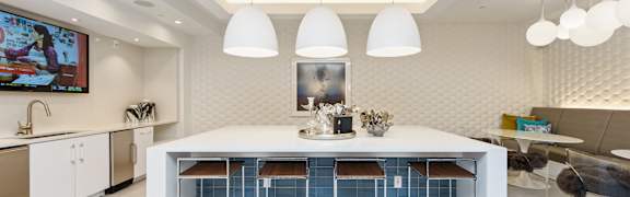 A modern kitchen with a white table and blue chairs.