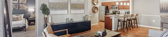 A living room with a grey couch and a wooden chair at Cumberland Place Apartment Homes, Texas