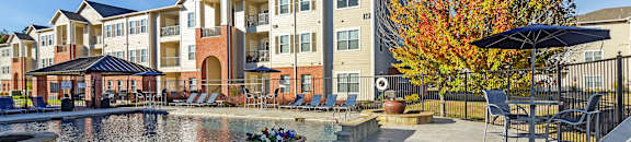 A large apartment complex with a courtyard and a fountain at Cumberland Place Apartment Homes, Tyler