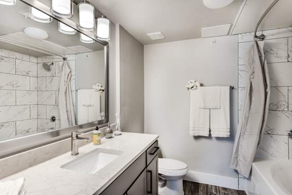 A bathroom with a marble countertop and a white toilet.