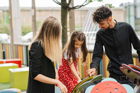 A woman and a young girl are playing on a playground.