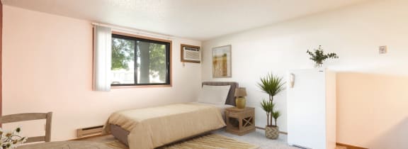 Mandan, ND Garden Grove Apartments.  a bedroom with a bed and a table