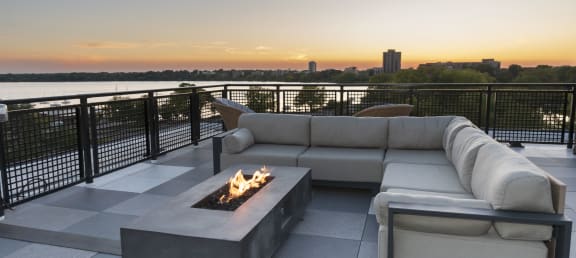 a living room with a couch and a fire pit on a rooftop