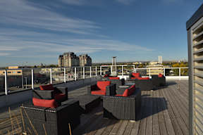 A rooftop patio with black and red furniture.