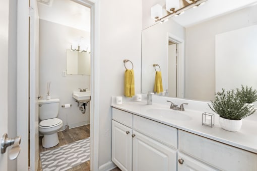 a bathroom with white cabinets and a yellow towel at Rivers Landing Apartments, PRG Real Estate, Hampton, Virginia