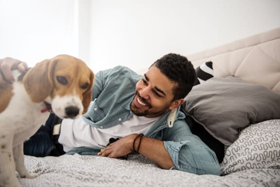 a man laying in bed with his dog