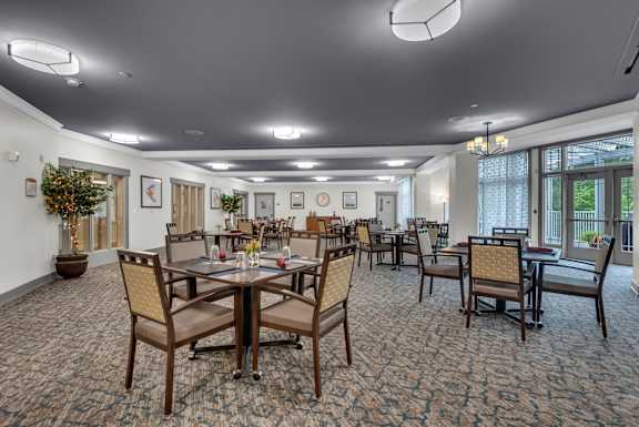 A large room with tables and chairs and a carpet.