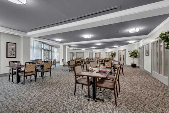 A large room with tables and chairs is set up for a meeting or event.