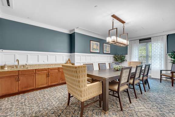 A dining room with a wooden table and chairs.
