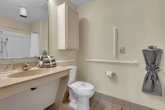 A white toilet sits next to a sink in a bathroom.
