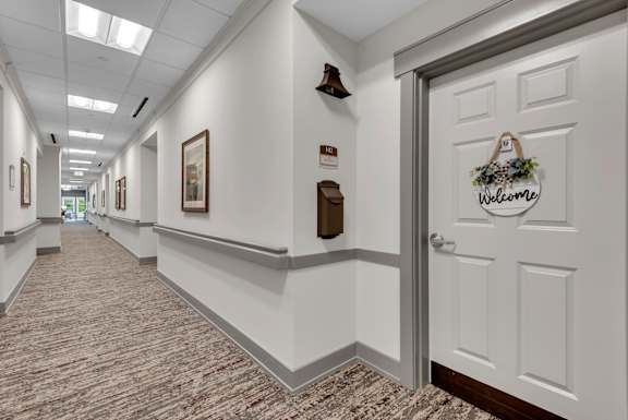 A hallway with a door on the right that has a sign on it.