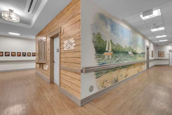 A room with a mural of a sailboat on the wall.