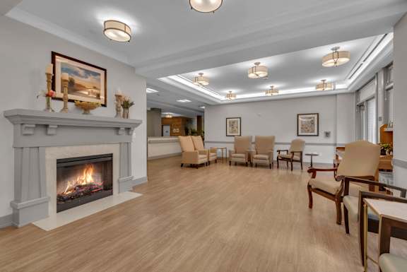 A living room with a fireplace and chairs.