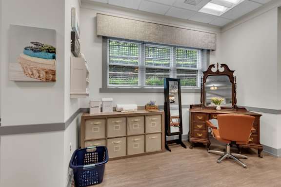 A room with a desk, chair, and storage drawers.