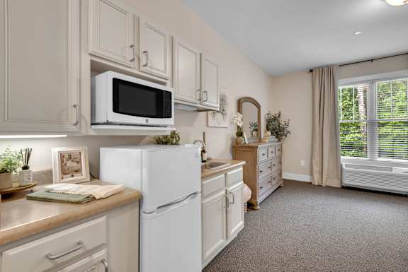 A kitchen with white appliances and cabinets.
