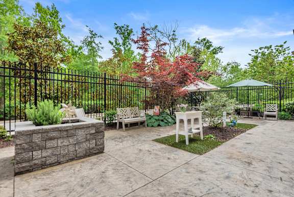 A patio with a table and chairs surrounded by a black fence.