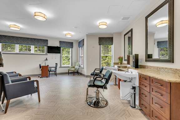 A well-lit room with a vanity table and chairs.