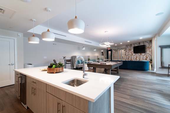 A modern kitchen with a white countertop and wooden cabinets.