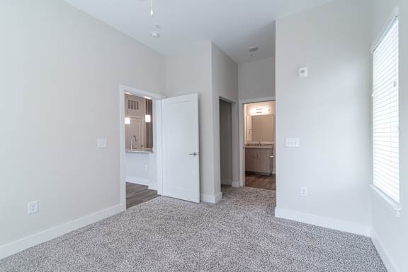 A spacious room with a carpeted floor and white walls.