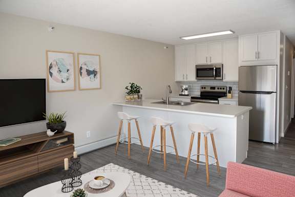 A modern kitchen with white cabinets and stainless steel appliances.