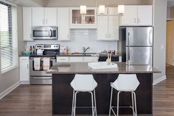a modern kitchen with stainless steel appliances and white cabinets