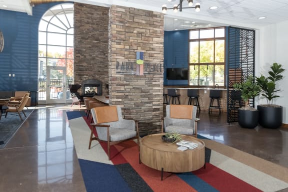 a lobby with a fireplace and chairs and a table