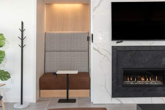 A modern living room with a fireplace and a flat screen TV mounted on the wall.