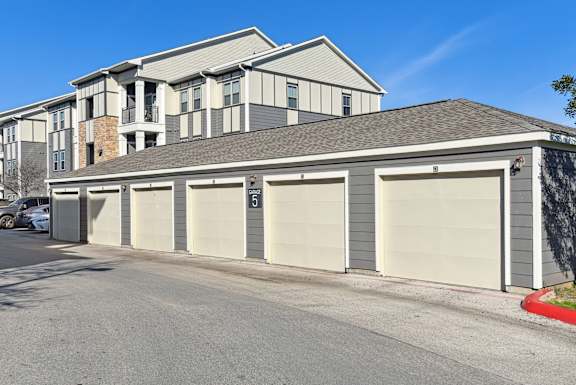a garage with four doors in front of a house