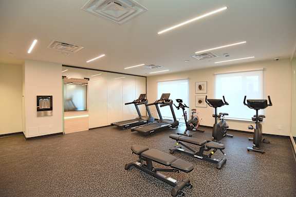 A gym with treadmills and exercise bikes at Roxy Apartments, Hamilton, Ontario