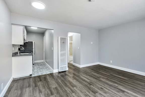 A kitchen area with a refrigerator, sink, and a microwave.