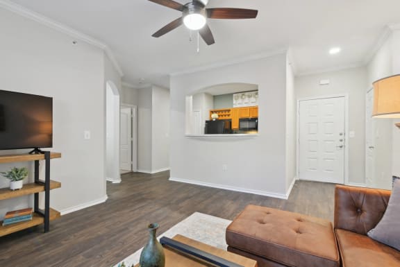 a living room with a couch and a ceiling fan at The Canyons Apartments, Fort Worth, TX