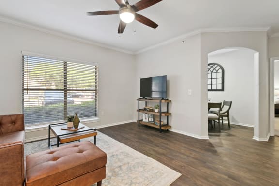 a living room with a couch and a ceiling fan at The Canyons Apartments, Fort Worth, TX