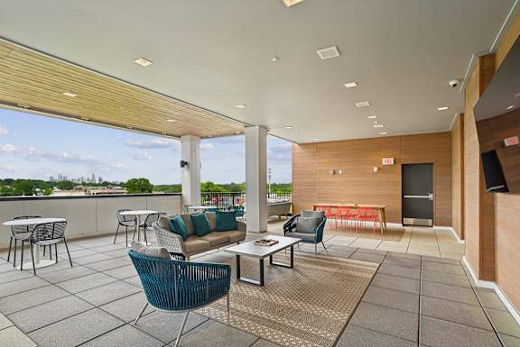 A patio with a table and chairs overlooking a cityscape.