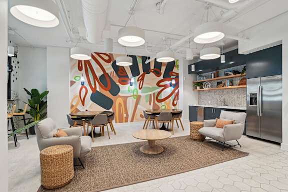 A modern living room with a large abstract painting on the wall.