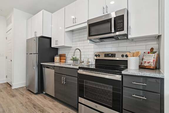 A kitchen with black and white appliances and cabinets.