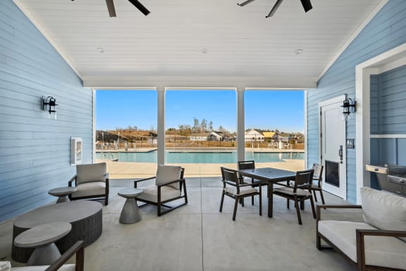 a porch with a pool and patio furniture and a view of the water
