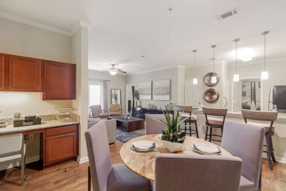 a rendering of a living room with a kitchen in the background at Cumberland Place Apartment Homes, Texas 75703