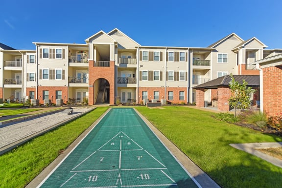 an apartment building with a green lawn and a sidewalk at Cumberland Place Apartment Homes, Tyler 75703
