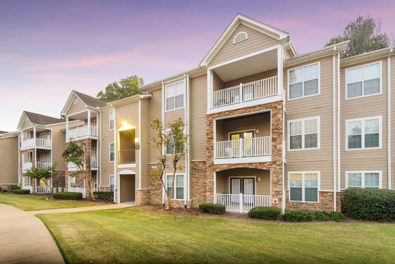 a large green apartment building with trees in front of it  at Quail Ridge Highlands Apartment Homes, Bartlett, 38135
