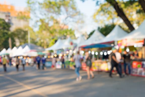 people walking through a fair with tents in the background  at The Hemlock, Washington, 98103