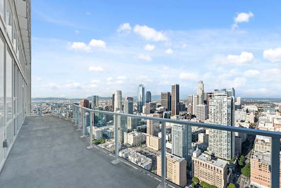 A cityscape with a clear blue sky and a river running through it. at Olympic + Hill Apartments, Apartments, Los Angeles, CA
