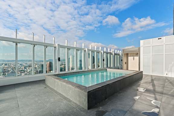 A rooftop pool with a view of the city. at Olympic + Hill Apartments, Apartments, Los Angeles, CA